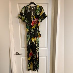 Zara silk-like jumpsuit with floral pattern on black background. Straight legs.